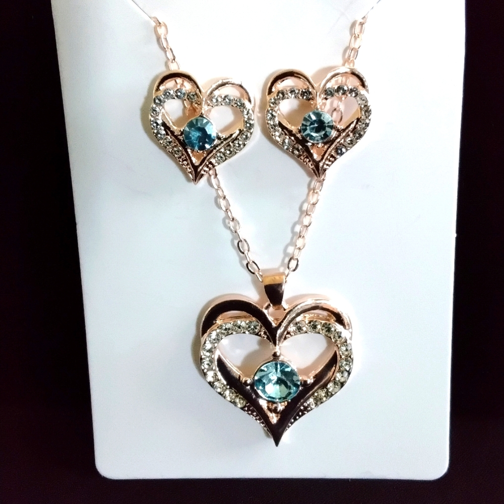 Gold zirconium heart with light blue jewel, on a 8 inch chain. With matching ear